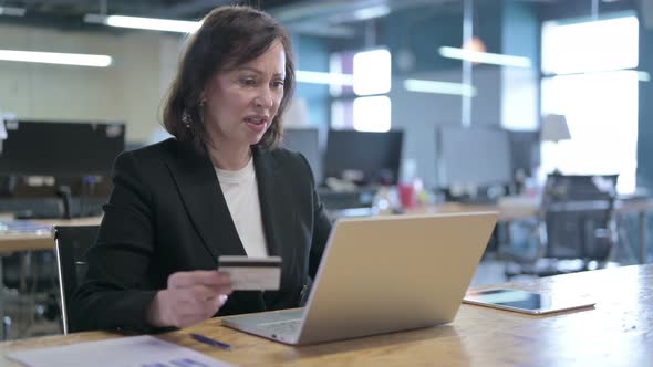 Angry Middle Aged Businesswoman Feeling Annoyed By Online Payment Failure in Office