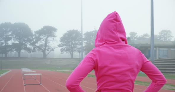 Female athlete standing on a running track 4k