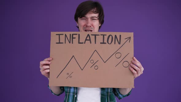 Crying Man in Shirt Holding Up a Sign with Rising Inflation Graph on Purple Background