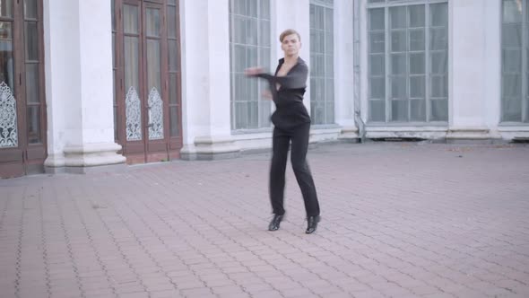 Wide Shot of Skilled Professional Ballet Dancer Spinning and Jumping in Urban City