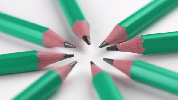 Sharpened wooden pencils on a white background arranged in a circle shape. School supplies