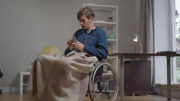 Rich Happy Satisfied Disabled Young Man in Wheelchair Indoors with Wallet Holding Cash Smiling