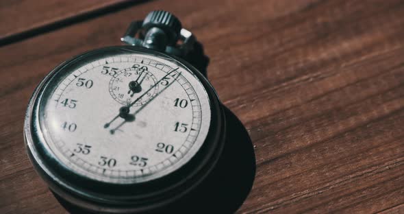 Old Vintage Stopwatch Lies on Wooden Table and Counts the Seconds