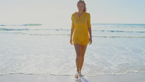 Front view of young Cuacasian woman walking on the beach 4k