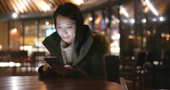 Woman using mobile phone at night