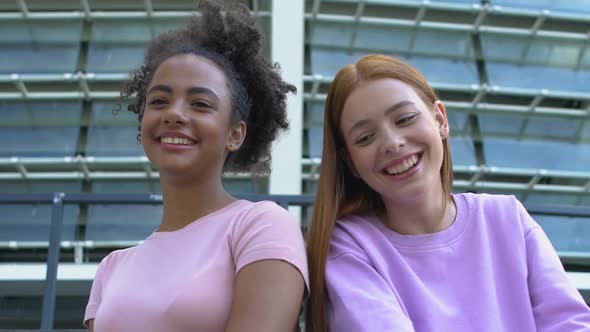 Playful Multiracial Female Friends Communicating With Friends Near Academy