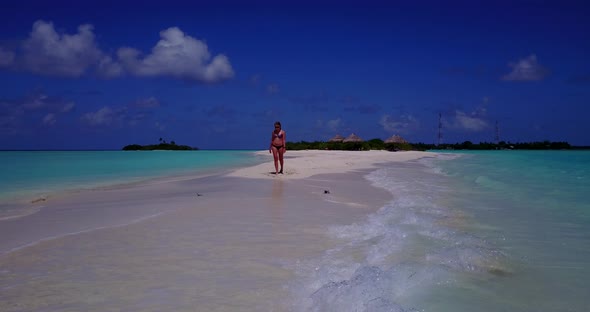 Young smiling girls on photoshoot in the sun at the beach on paradise white sand and blue background