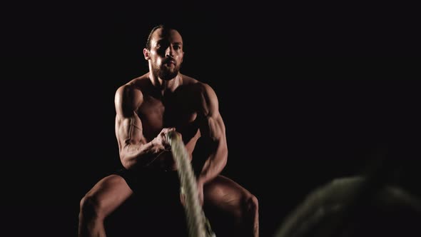 Muscular Man Training with Battle Ropes