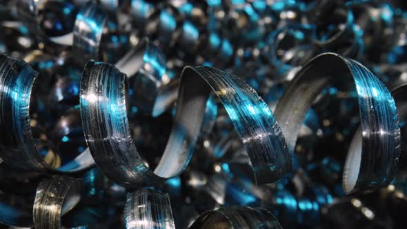 Camera Pans Along Shiny Metal Shavings Illuminated By Blue Neon Lights