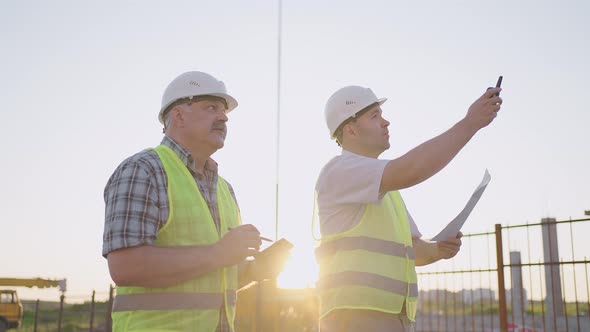 Portrait of Two Builders Standing at Building Site