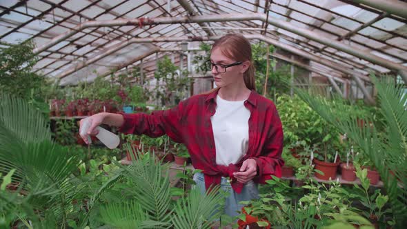 Girl with Glasses Sprays Plants From a Splash or Spray