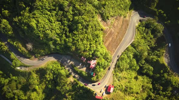 Cars driving on a winding road in a tropical valley in Costa Rica.