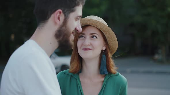 Happy Couple in Love Talking with Smile and Girl Kisses Her Man on Street