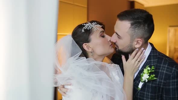 Close-up View of a Happy Wedding Couple Kissing in a Luxury Room of an Expensive Hotel. A Bearded