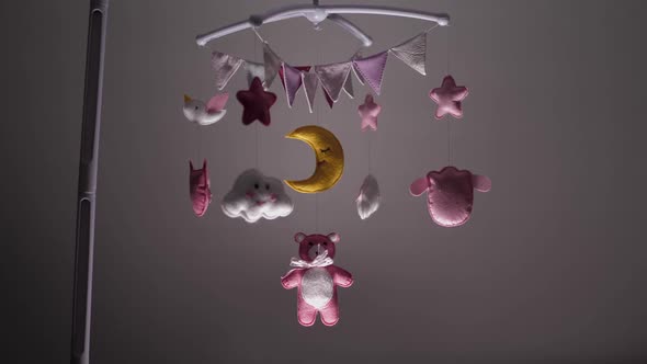 Baby Mobile with Pink Handstitched Animal and Bird Toys with Yellow Moon on White Wall Background