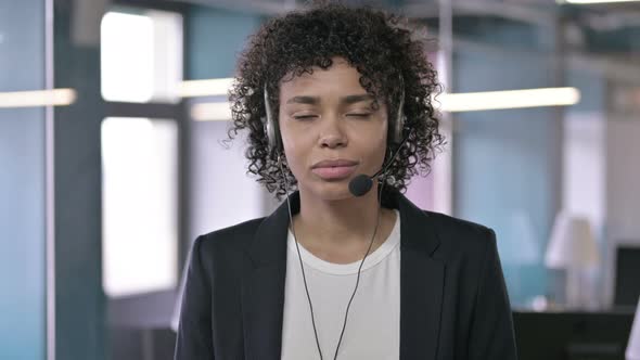 Portrait of Serious African Businesswoman Listening Through Head Phones