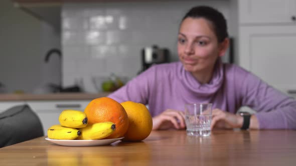 Young Woman at Home Drinks Water and Wants To Eat. Intermittent Fasting Concept