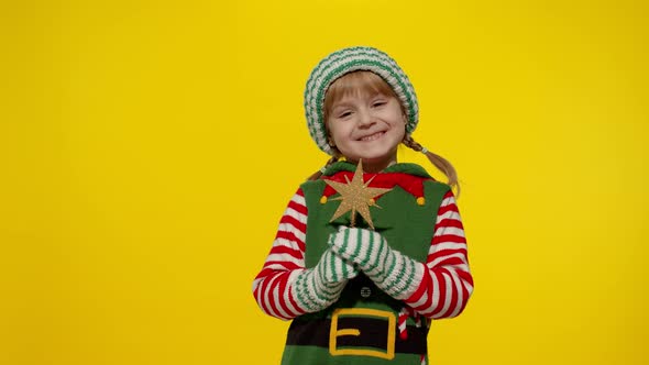 Kid Girl in Christmas Elf Santa Helper Costume Holding Star Toy and Making a Wish