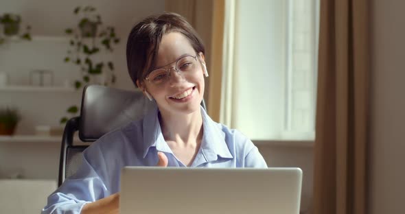 Charming Caucasian Woman Sitting at Home Office Table, Using Laptop Computer To Communicate. Smiling