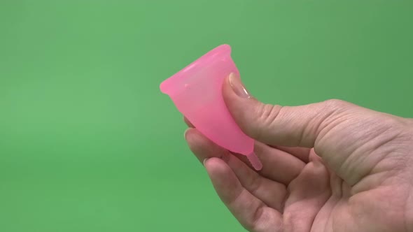 Pink Menstrual Cup Closeup on Green Background