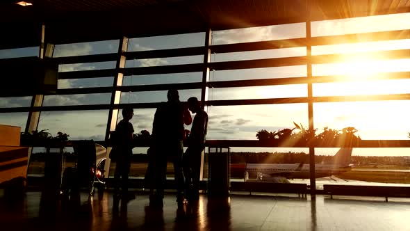 Silhouettes of Passengers in the Airport Lounge During Sunset