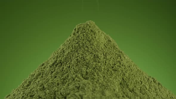 Pouring green superfoods powder close up