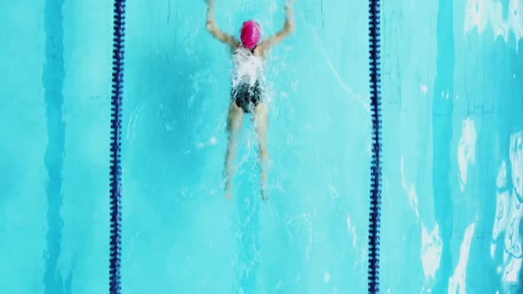 From Above View of Female Professional Athlete Training and Swimming in Breaststroke Style in Clear