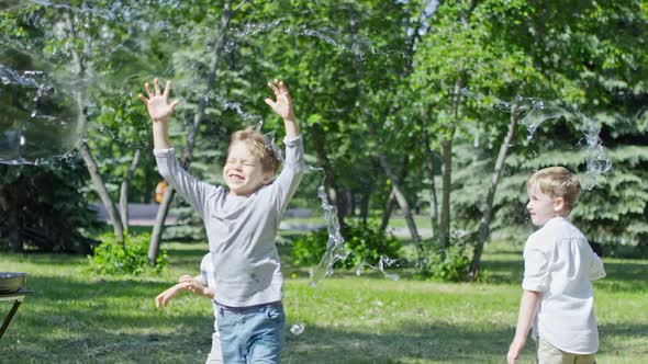 Adorable Little Boys Bursting Giant Soap Bubble During Performance