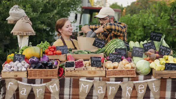 Farmers Couple Selling Fresh Vegetables and Fruits at the Farmers Market