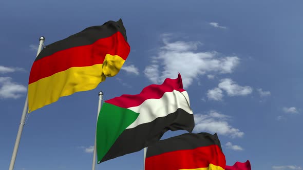 Waving Flags of Sudan and Germany on Sky Background