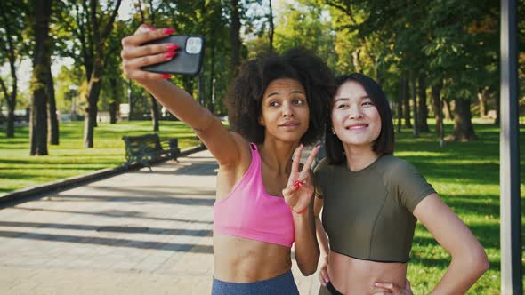 African American Woman Taking Selfie with Her Asian Friends During Workout in City Park Tracking