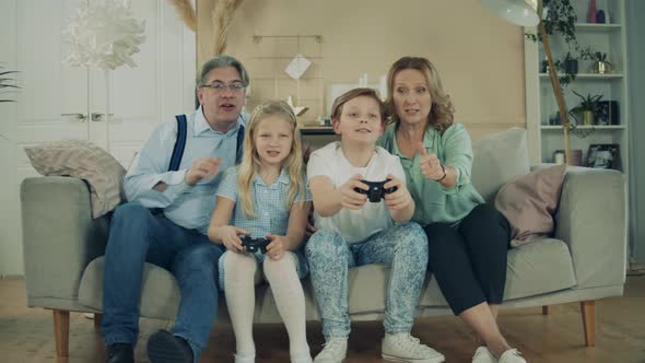 Kids Are Sitting with Their Grandparents and Playing Console