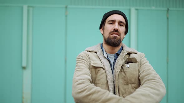 Confident bearded man wearing hat looking at the camera