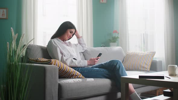 Woman Is Relaxing At Home Using Smartphone
