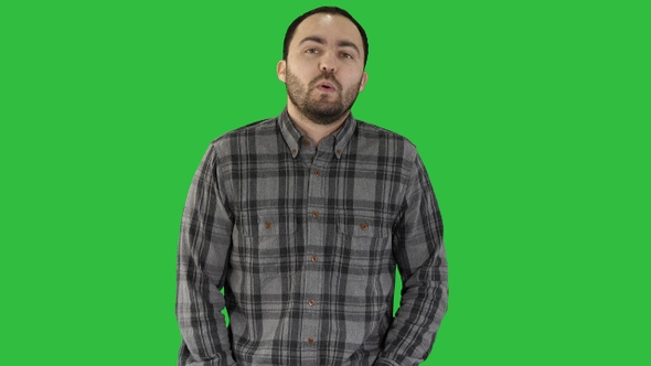 Young man walking and whistling on a Green Screen, Chroma Key