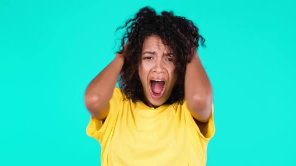 Portrait of Unpleasantly Surprised Shocked Mixed Race Girl on Teal Studio Background