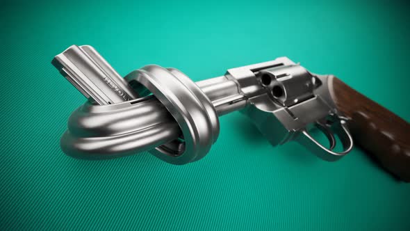 Revolver with a knot on the barrel. Metallic handgun laying on green fabric