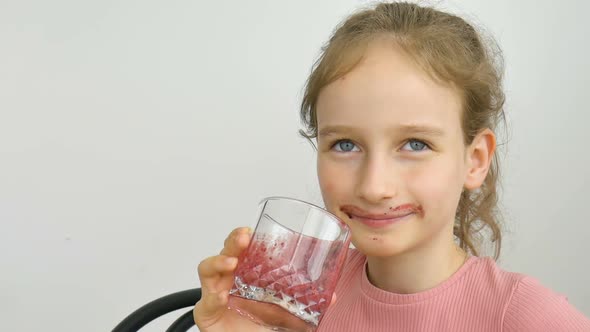 Sweet Little Girl Drinks Raspberry Smoothie and Smiles