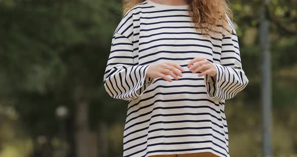 woman making heart gesture with hands. girl wearing striped blouse cropped video. High quality 4k