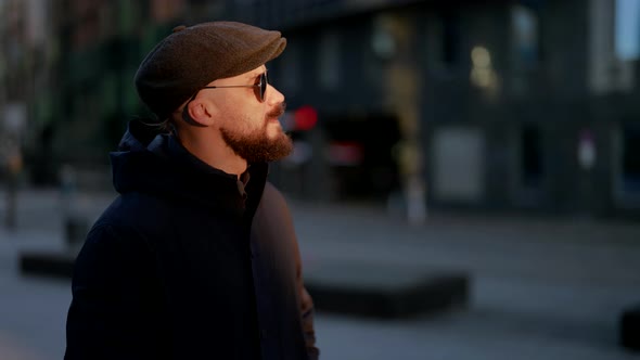 Portrait of a Mustachioed and Bearded Man in a Cap and Sunglasses