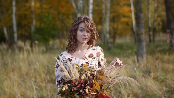 Portrait of Woman Looking at Bouquet of Wild Flowers in Summer.