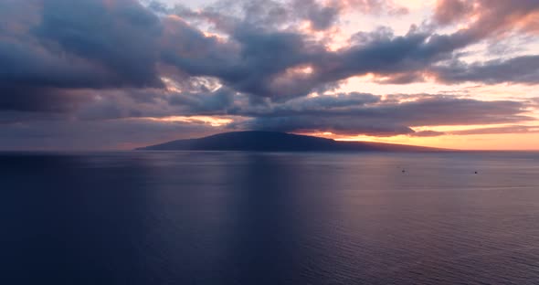 aerial views of  bleeding orange sunset behind lanai island with sailboats