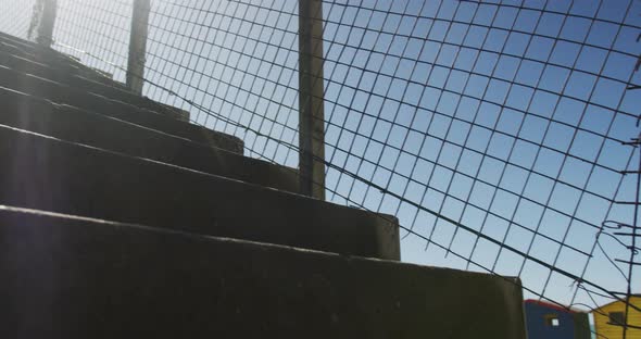 Focused african american man running up the stairs, exercising outdoors on sunny day