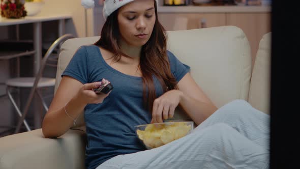 Woman with Santa Hat Watching Television on Christmas Eve