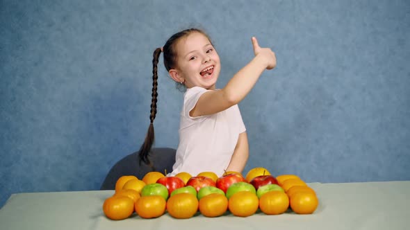 Portrait of cute cheerful little girl with fruit
