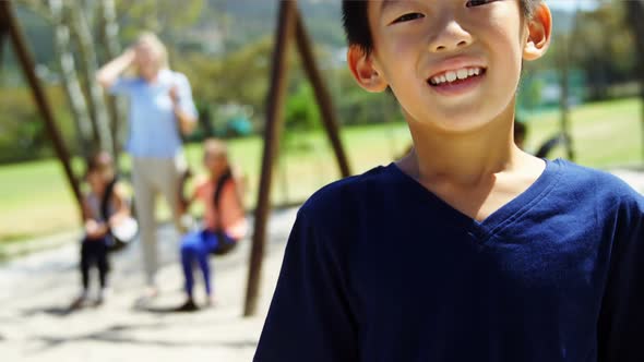 Portrait of happy schoolboy standing in playground