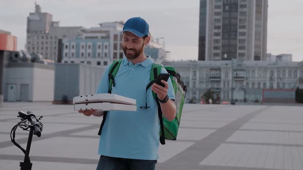 Delivery Man Doing Fast Food Delivery Service with Electric Scooter Taking Order Via App in Smart