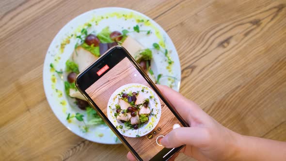 Girl Blogger Shoots a Dish with Food on Her Smartphone