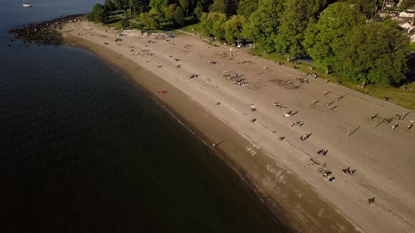 People Sunbathing And Enjoying The Reopened Kitsilano Beach With Downtown Skyline And English Bay Be