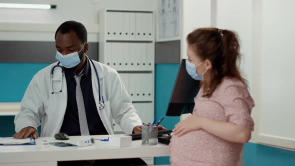 Medical Specialist Giving Bottle of Prescription Pills to Pregnant Patient